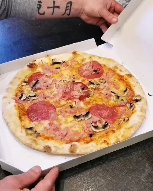 Pizza so salámou, šunkou a šampiňónmi v otvorenej krabici